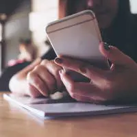 woman holding an ipad looking at analytics information and graphs surrounded by two other people looking at the data