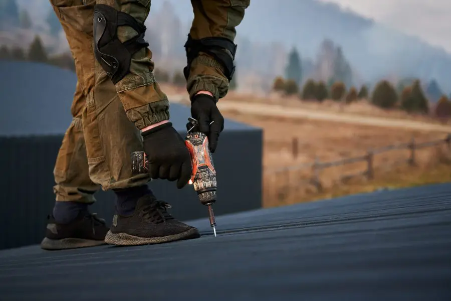 Person screwing in metal roofing