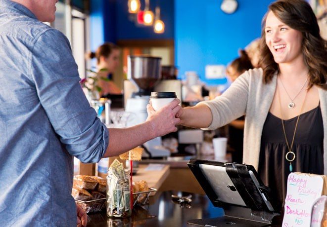 Matt Konen taking a cup of coffee from a barista in Bozeman, MT