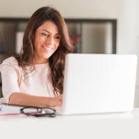 woman holding an ipad looking at analytics information and graphs surrounded by two other people looking at the data